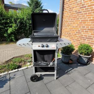 een grill op een patio naast een bakstenen gebouw bij Ferienwohnung Abendsonne in Zarrentin