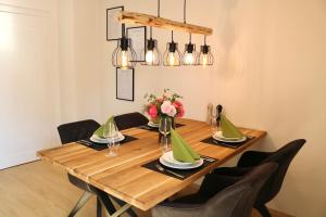 a dining room table with chairs and a wooden table with flowers at Moderne Ferienwohnung im Allgäu in Erkheim