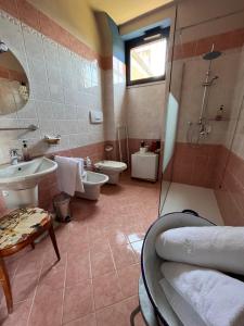 y baño con 2 aseos, lavamanos y ducha. en The Tower Of The Old King, en Desenzano del Garda