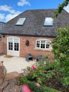 a brick house with two windows and a patio at The Stable Loft. NEC, Airport in Fillongley