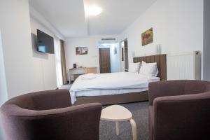 Habitación de hotel con 1 cama y 2 sillas en Acomodoro Residence, en Bucarest