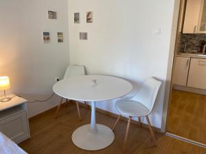 a white table and two chairs in a kitchen at Aranyhíd B-1 apartman in Balatonfüred