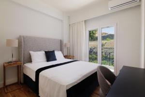 a bedroom with a large bed and a window at Vanda's Maison in Corfu Town