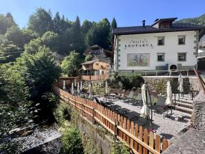 un restaurante con sombrillas y sillas frente a un edificio en Bajta Kroparica, en Kropa