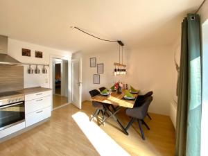 a kitchen and dining room with a table and chairs at Moderne OG-Wohnung im Allgäu in Erkheim