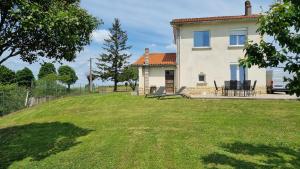 uma casa com um quintal com cadeiras e uma mesa em Gîte du vignoble em Puisseguin