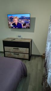 Gîte du vignoble في Puisseguin: تلفزيون على جدار فوق خزانة في غرفة النوم