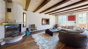 uma sala de estar com um sofá e uma lareira em Chalet Zeppelin em Château-d'Oex