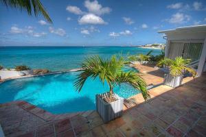 a swimming pool with a view of the ocean at Ocean front villa, pool, private ocean snorkeling in Simpson Bay