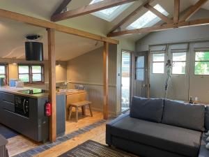 a living room with a couch and a kitchen at Faraway Follies in Llandegla