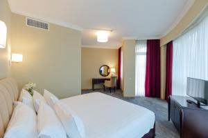 バトゥミにあるHotel Aisiのベッド1台、薄型テレビが備わるホテルルームです。