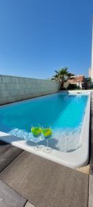 a pool with two green chairs sitting next to a swimming pool at Apartments Amesia with pool, Novalja in Novalja