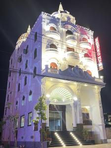 um grande edifício com uma fachada iluminada à noite em Hotel Hoàng My em Pleiku