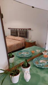 een slaapkamer met een bed met borden en potplanten bij JONIA Appartamento vacanze vicino al mare con giardino in Pulsano
