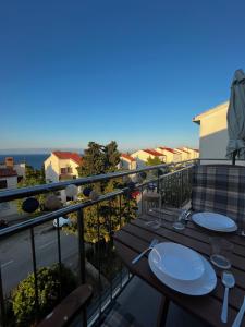 a balcony with two tables and a view of the ocean at Falcon in Mali Lošinj