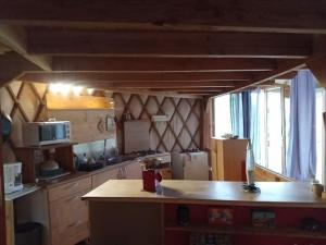 a kitchen with a counter top and a refrigerator at Charmante Yourte contemporaine in Carmaux