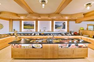 a large kitchen with wooden cabinets and a large island at Alpenhotel Wanderniki in Liesing