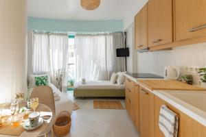 Theseus Zen Luxury Suite في مدينة هيراكيلون: مطبخ وغرفة معيشة مع طاولة وأريكة