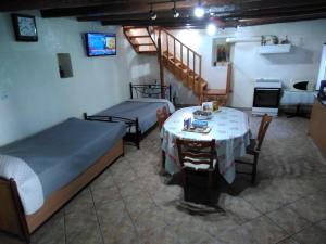 a room with two beds and a table and a tv at MATAS HOUSE in Leonidion