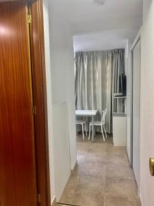 a hallway with a room with a table and a dining room at My Pretty Payma Apartamentos in Benidorm