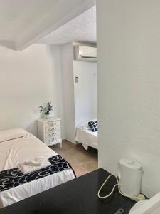 1 dormitorio con 2 camas y espejo en My Pretty Payma Apartamentos, en Benidorm