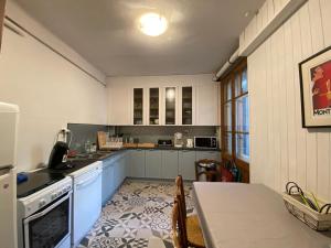 夏蒙尼-勃朗峰莱昂别墅的厨房配有蓝色橱柜和桌子