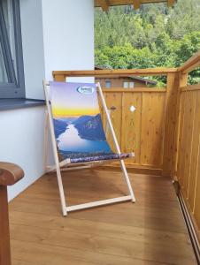 un cuadro sentado en una silla en un balcón en Zimmer bei Landhaus Mayr en Maurach