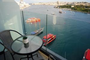 a glass table with a view of a body of water at The Londoner Hotel Sliema in Sliema