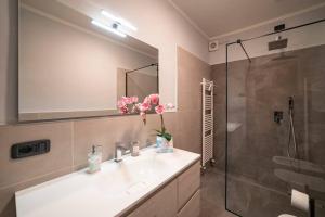 La salle de bains est pourvue d'un lavabo et d'une douche. dans l'établissement Crossing Home - Zentrum, à Iseo