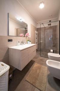 La salle de bains est pourvue d'un lavabo, de toilettes et d'un miroir. dans l'établissement Crossing Home - Zentrum, à Iseo