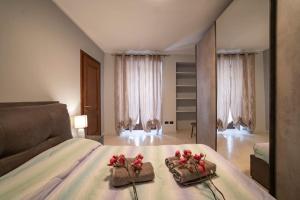- une chambre avec un lit et 2 serviettes avec des fleurs dans l'établissement Crossing Home - Zentrum, à Iseo