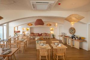 a restaurant with wooden tables and chairs in a room at Praia FLH Hotels Ericeira in Ericeira