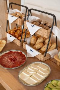 a table with different types of bread and pastries at Praia FLH Hotels Ericeira in Ericeira