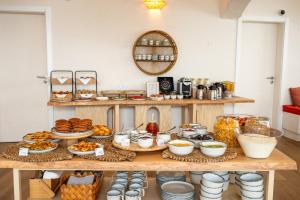 a table with various food items on it at Praia FLH Hotels Ericeira in Ericeira