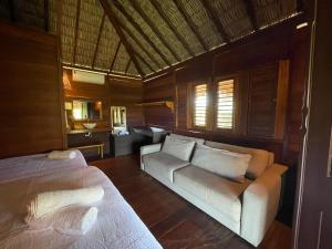 ein Wohnzimmer mit 2 Betten und einem Sofa in der Unterkunft Atins Bangalôs in Atins