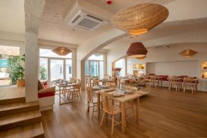 a restaurant with tables and chairs in a room at Praia FLH Hotels Ericeira in Ericeira