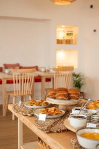a table with plates and bowls of food on it at Praia FLH Hotels Ericeira in Ericeira