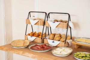 a table with different types of bread and cheese at Praia FLH Hotels Ericeira in Ericeira