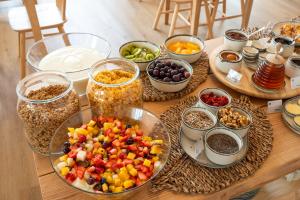 a table topped with bowls of food and bowls of fruit at Praia FLH Hotels Ericeira in Ericeira