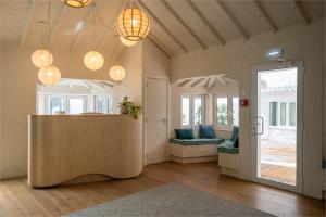a living room with a table and some windows at Praia FLH Hotels Ericeira in Ericeira
