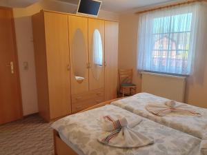 a bedroom with two beds and a cabinet and a window at Ferienwohnung 2, oben in Bad Wilsnack