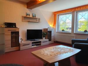 a living room with a tv and a coffee table at Ferienwohnung 2, oben in Bad Wilsnack