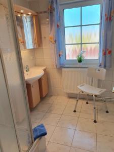 a bathroom with a sink and a chair and a window at Ferienwohnung 2, oben in Bad Wilsnack