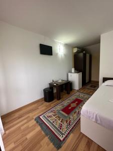 a room with a bed and a table and a tv at Casa Cu Flori Corbu in Corbu