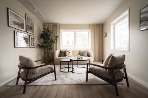 - un salon avec deux chaises et une table dans l'établissement Enter Viking Apartment Hotel, à Tromsø