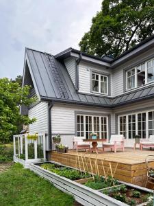 une maison avec une terrasse en bois dans la cour dans l'établissement Villa Meidi, à Võsu
