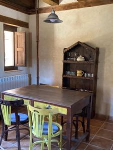 Un comedor con mesa y sillas de madera. en La Caracola, en Caracena 33 fotos más