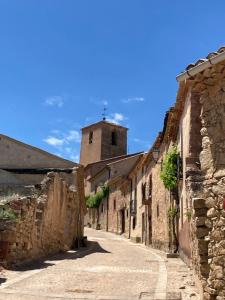 un callejón con un edificio con una torre en el fondo en La Caracola, en Caracena
