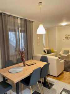 een eettafel met stoelen en een woonkamer bij Apartments Zenta Split in Split