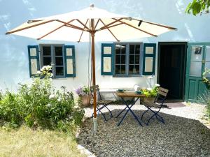 a table with an umbrella in front of a house at Benefizium Denklingen - Anno 1713 in Denklingen